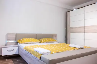 a bedroom with a bed with yellow sheets and pillows at Campi d’Oro in Kotor