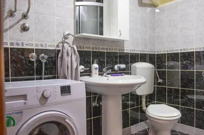 a bathroom with a washing machine and a sink at Campi d’Oro in Kotor