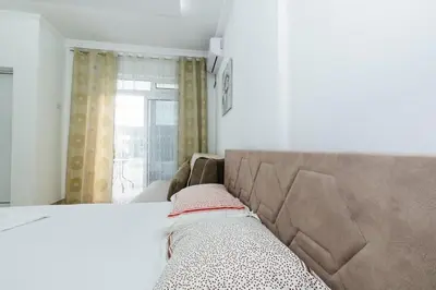a bedroom with a bed and a window with a curtain at Flori Apartments in Ulcinj