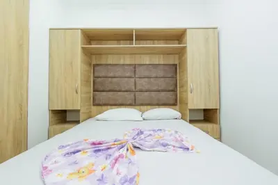 a bedroom with a bed with a wooden headboard at Flori Apartments in Ulcinj