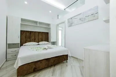 a bedroom with a large bed in a white room at Flori Apartments in Ulcinj