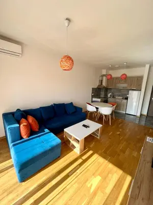 a living room with a blue couch and a table at Z apartment in Podgorica