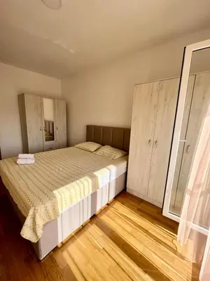 a bedroom with a bed and wooden floors at Z apartment in Podgorica