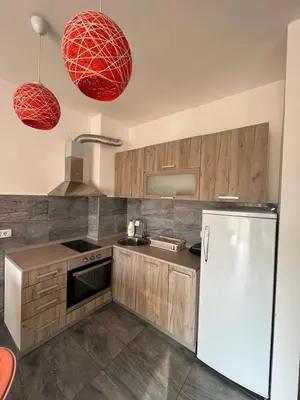 a kitchen with a white refrigerator and two red pendant lights at Z apartment in Podgorica