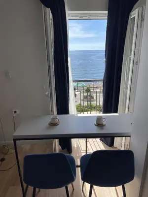 a table with two chairs and a view of the ocean at Lungomare Apartments in Petrovac na Moru