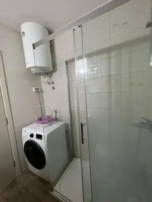 a shower stall with a washing machine in a bathroom at Oscar in Podgorica