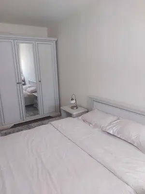 a bedroom with a white bed and a mirror at Oscar in Podgorica