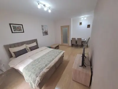 a bedroom with a large bed and a table at Apartman City kvart in Podgorica