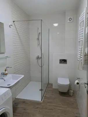 a bathroom with a shower and a toilet and a sink at Apartman City kvart in Podgorica
