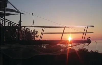a boat in the water with the sunset in the background at Nice Apartment In Utjeha With Kitchen in Utjeha