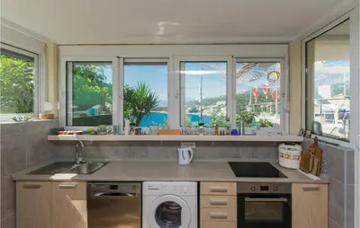 a kitchen with a sink and a washing machine at Nice Apartment In Utjeha With Kitchen in Utjeha