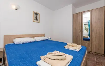 a bedroom with a blue bed with towels on it at Nice Apartment In Utjeha With Kitchen in Utjeha