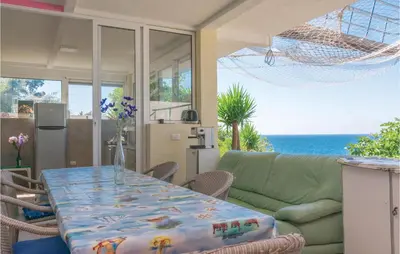 a dining room with a table and a couch at Nice Apartment In Utjeha With Kitchen in Utjeha