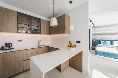 a kitchen with a white counter top and a bed at Hotel Aurel Coast in Kotor