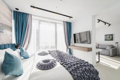a bedroom with a large bed with blue pillows at Hotel Aurel Coast in Kotor