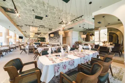 a dining room with white tables and chairs and tablesearcher at Hotel Aurel Coast in Kotor