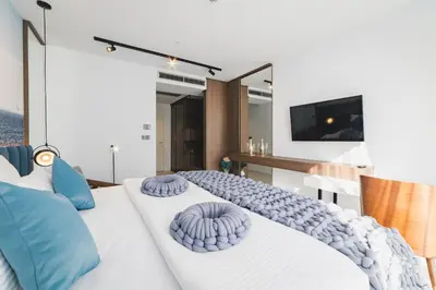 a bedroom with two beds with blue pillows at Hotel Aurel Coast in Kotor