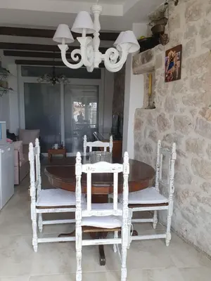 a table and chairs in a room with a stone wall at Stone house Djakonovic in Budva
