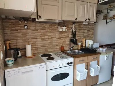 a kitchen with a white stove top oven next to a sink at Stone house Djakonovic in Budva