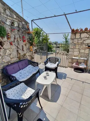a patio with a couch and chairs and a table at Stone house Djakonovic in Budva