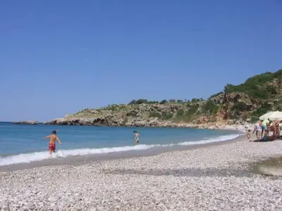 a group of people walking on a beach at Stone house Djakonovic in Budva