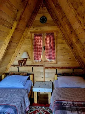 a attic room with two beds and a window at Private Camp - Wolf & Sheep - 4 bungalows- 8 person in Podgorica