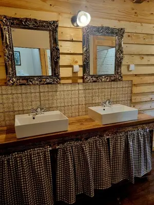 a bathroom with two sinks and a mirror at Private Camp - Wolf & Sheep - 4 bungalows- 8 person in Podgorica