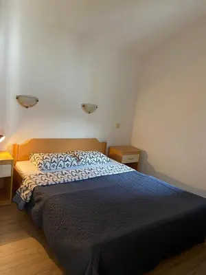 a bedroom with a bed with a blue comforter at Apartments Ivanišević in Kotor