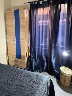 a bedroom with a bed and a dresser with curtains at Apartments Ivanišević in Kotor