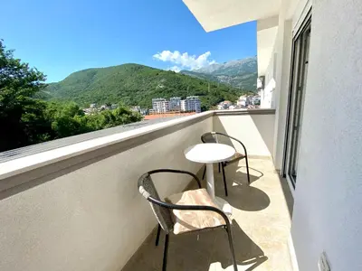 a balcony with two chairs and a table and a view at Apartments Popović in Budva