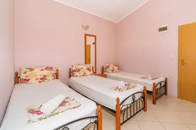a room with two beds and a mirror at Guest House Edita in Ulcinj