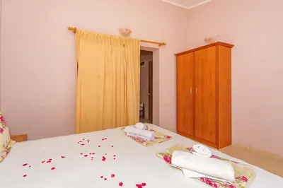 a bedroom with a bed with red flowers on it at Guest House Edita in Ulcinj
