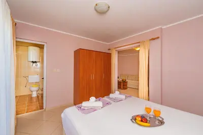 a bedroom with a bed with a tray of fruit on it at Guest House Edita in Ulcinj