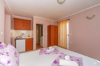 a room with a bed with purple pillows on it at Guest House Edita in Ulcinj