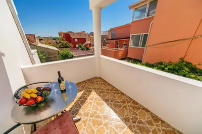 a table with a bowl of fruit on a balcony at Guest House Edita in Ulcinj