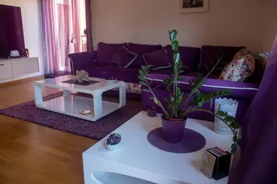 a living room with a purple couch and a table at Apartment Marija in Podgorica