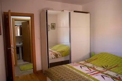 a bedroom with a mirrored closet and a bed at Apartment Marija in Podgorica