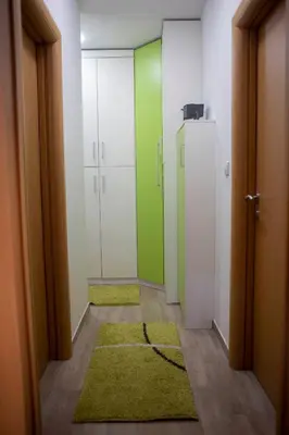 a hallway with green and white doors and rugs at Apartment Marija in Podgorica