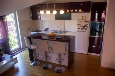 a kitchen with a island with a sink and a refrigerator at Apartment Marija in Podgorica