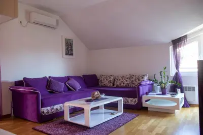 a living room with a purple couch and a table at Apartment Marija in Podgorica