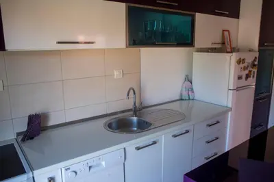 a kitchen with a sink and a white refrigerator at Apartment Marija in Podgorica