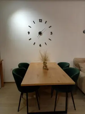 a table with green chairs and a clock on the wall at Solaris Apartments in Budva