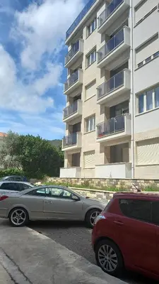 two cars parked in a parking lot in front of a building at Solaris Apartments in Budva