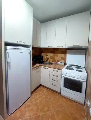 a kitchen with a white refrigerator and a stove at Apartman Maslina in Podgorica