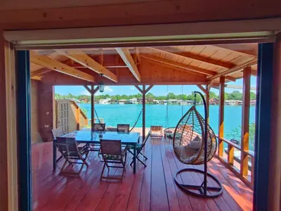 a deck with a blue table and chairs and a swing at Sojenica Tamara in Ulcinj