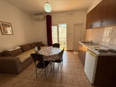 a kitchen and living room with a table and a couch at Apartments Marniković in Ulcinj