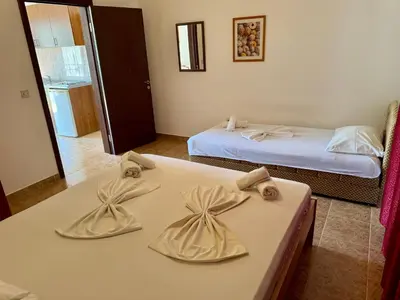 a room with two beds and a table with bows at Apartments Marniković in Ulcinj