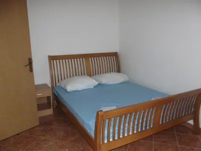a small bedroom with a bed with two pillows at Apartmani Stojanović in Sutomore