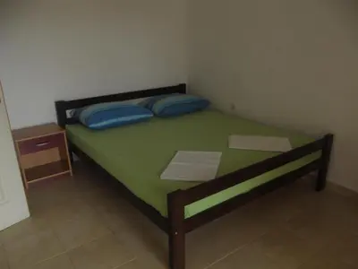 a small bedroom with a bed with blue pillows at Apartmani Stojanović in Sutomore
