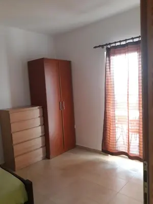 a bedroom with a closet and a dresser and a window at Apartmani Stojanović in Sutomore